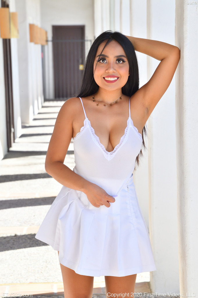 teen pornstar Luna FTV is wearing a white sexy dress and non nude showing her cleavage and left armpit while standing in Busty Teen in White